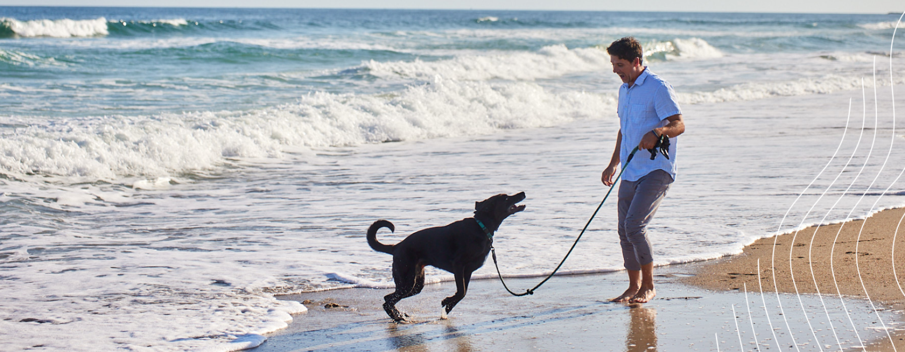 Man enjoying the beach and water with dog